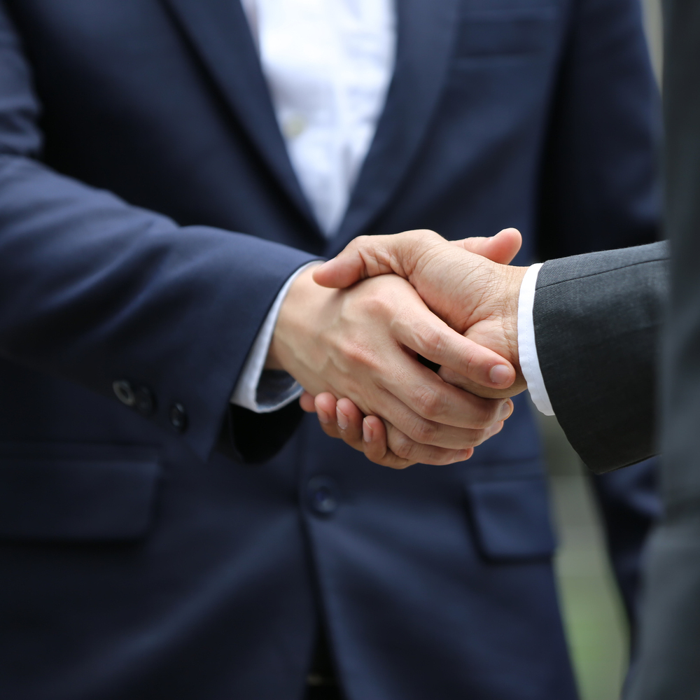 Business people shaking hands, finishing up a papers signing. Meeting, contract and lawyer consulting concept.